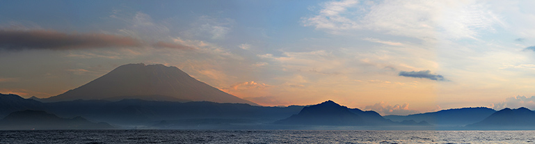 Východ slunce nad ostrovem Bali, vlevo hora Agung. Indonésie.
