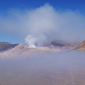 indonésie: Mlha opouští kalderu a odhaluje dýmající Bromo a hnědozelený zvrásněný Batok. 
